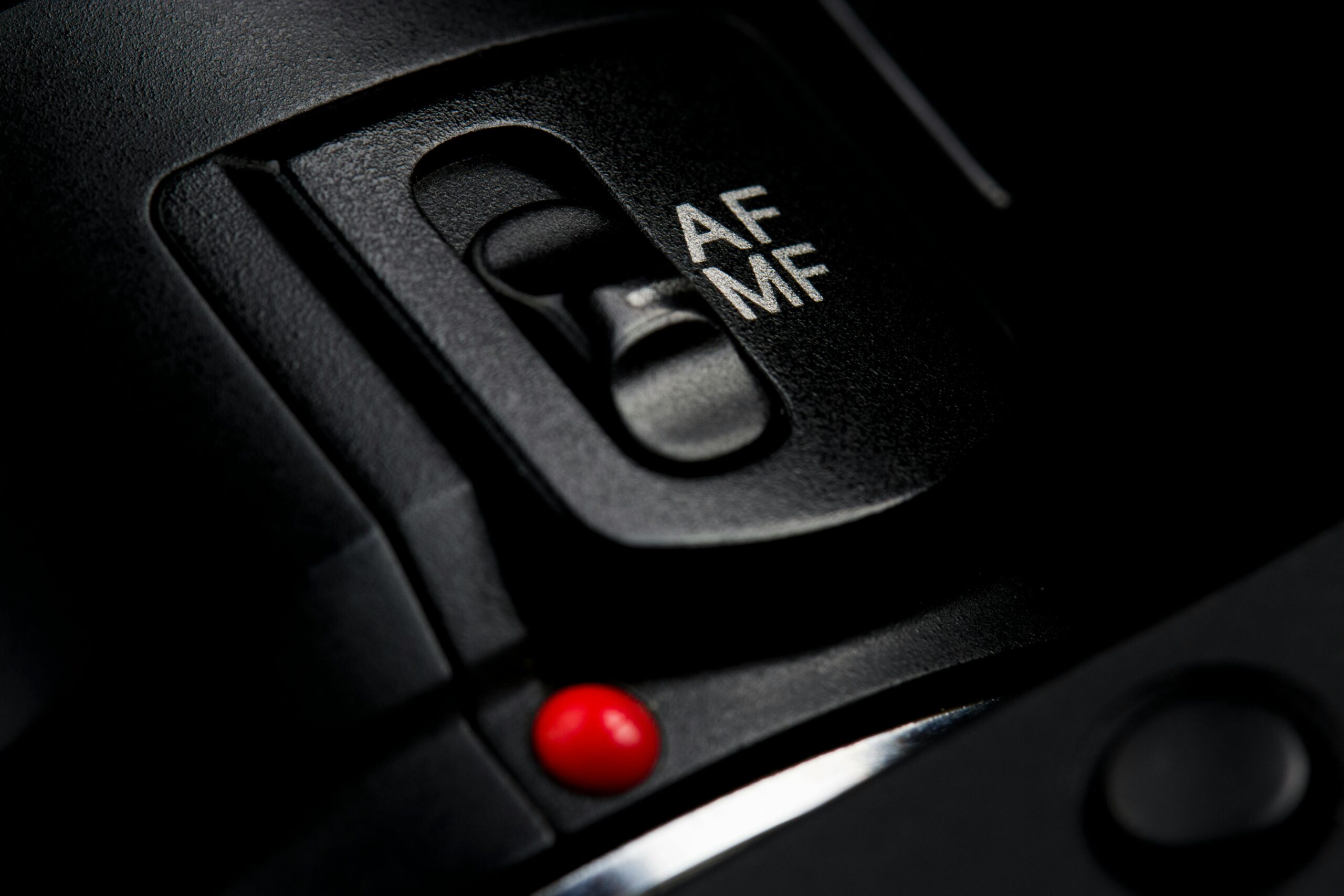 Detailed view of a DSLR camera's focus switch highlighting AF and MF modes.